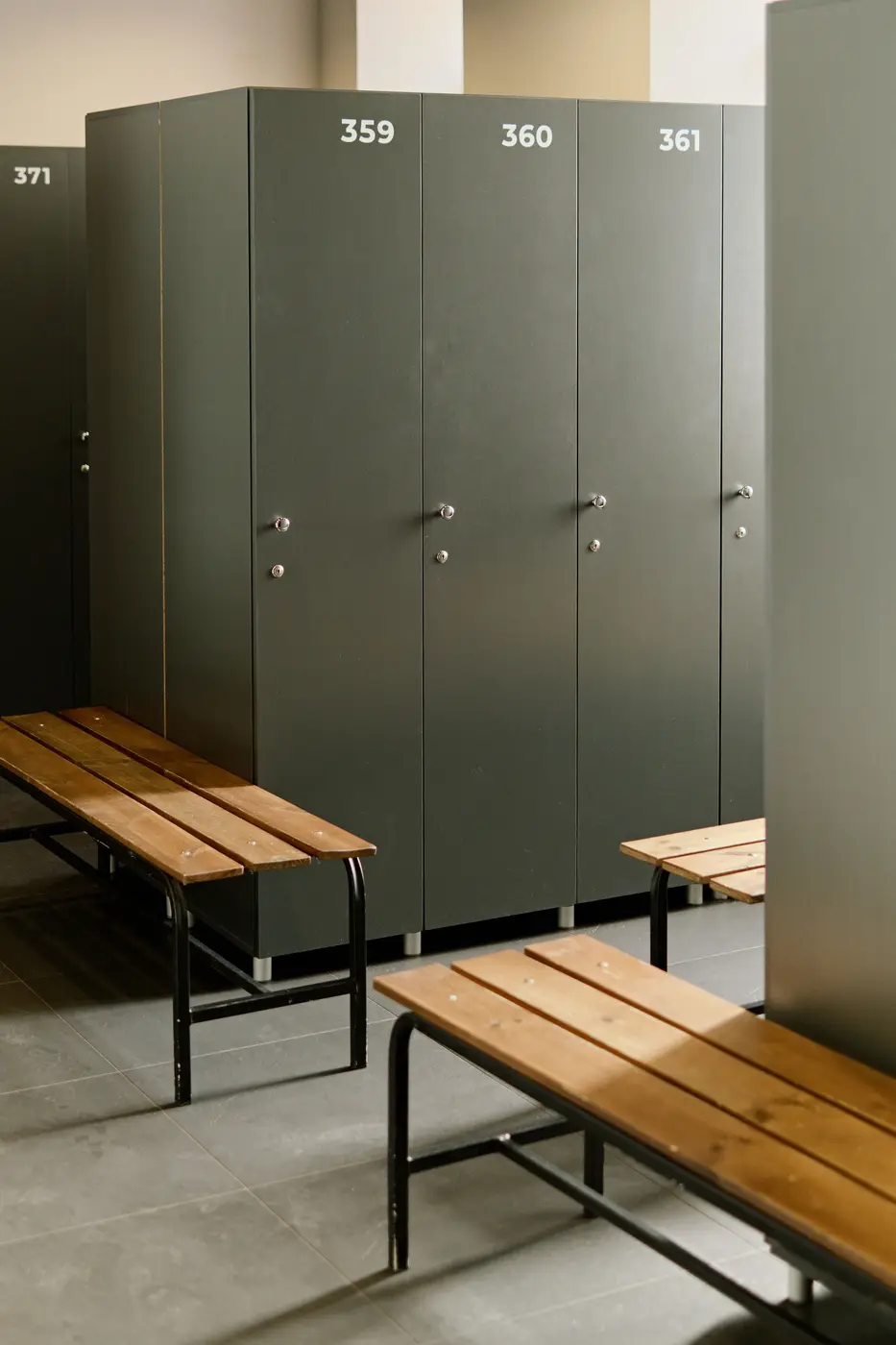 Grey lockers above a wooden bench in a changing room
