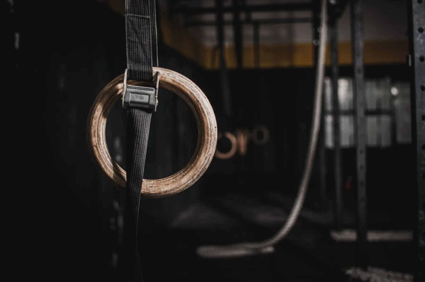 Gymnastic rings hanging from a rig in a dark gym